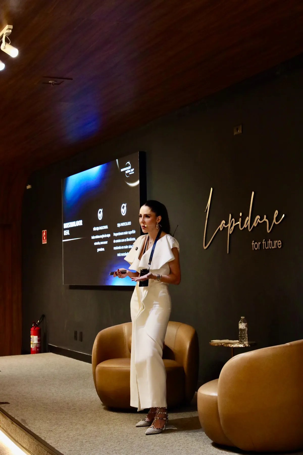 Dra. Manoela Fassina em palestra no palco
